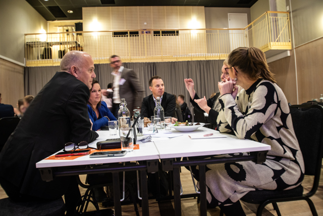 Företagsveckan i Hudddinge 2023. Flera personer sitter runt ett konferensbord och samtalar.